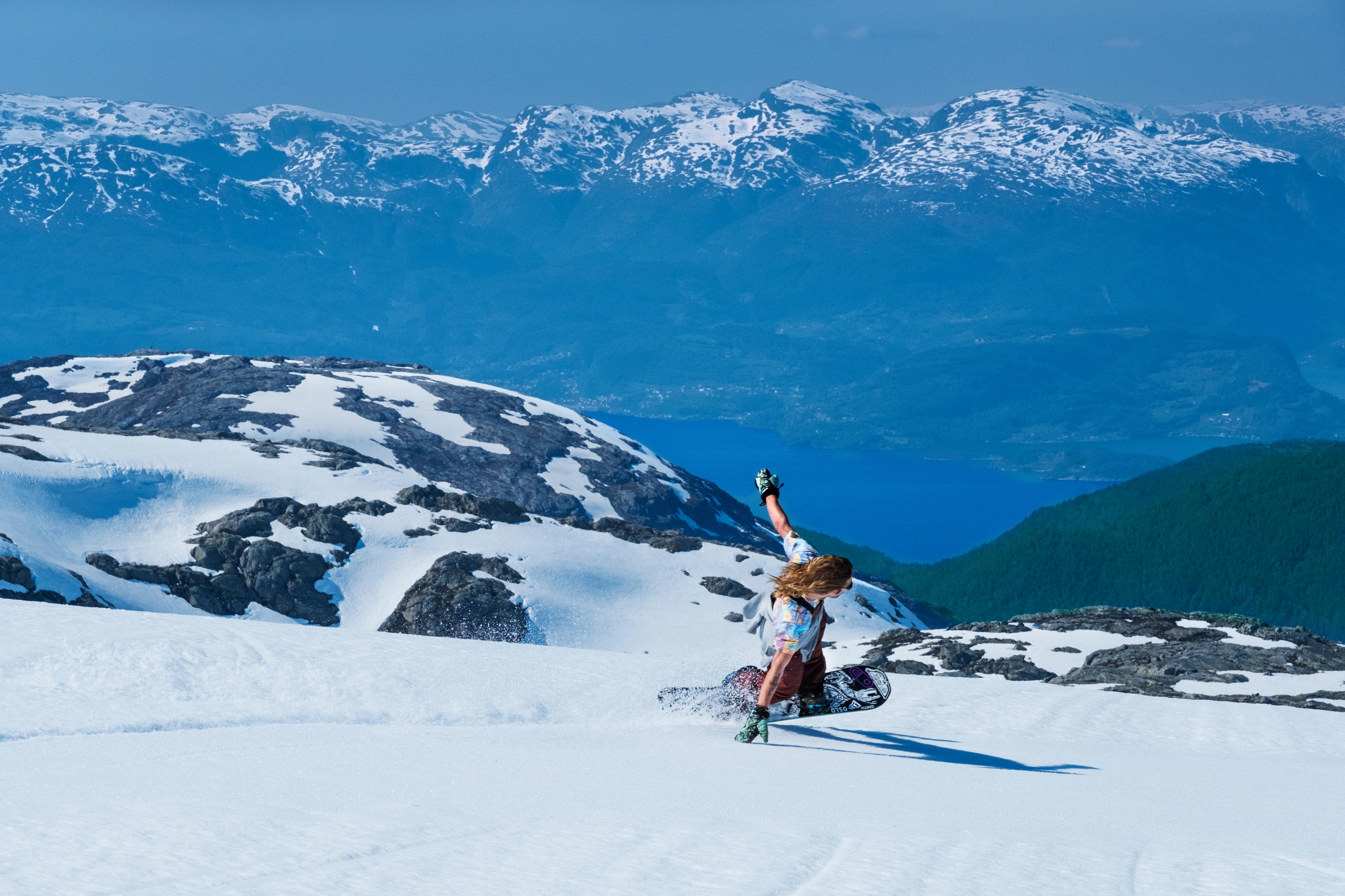 Snøbrettkøyrar på Fonna Glacier med fantastisk utsikt over fjord og fjell.