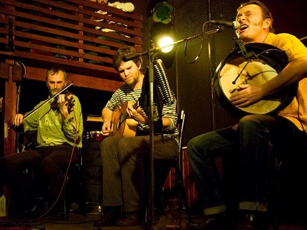 Tre musikere spiller på fiolin, gitar og bodhran