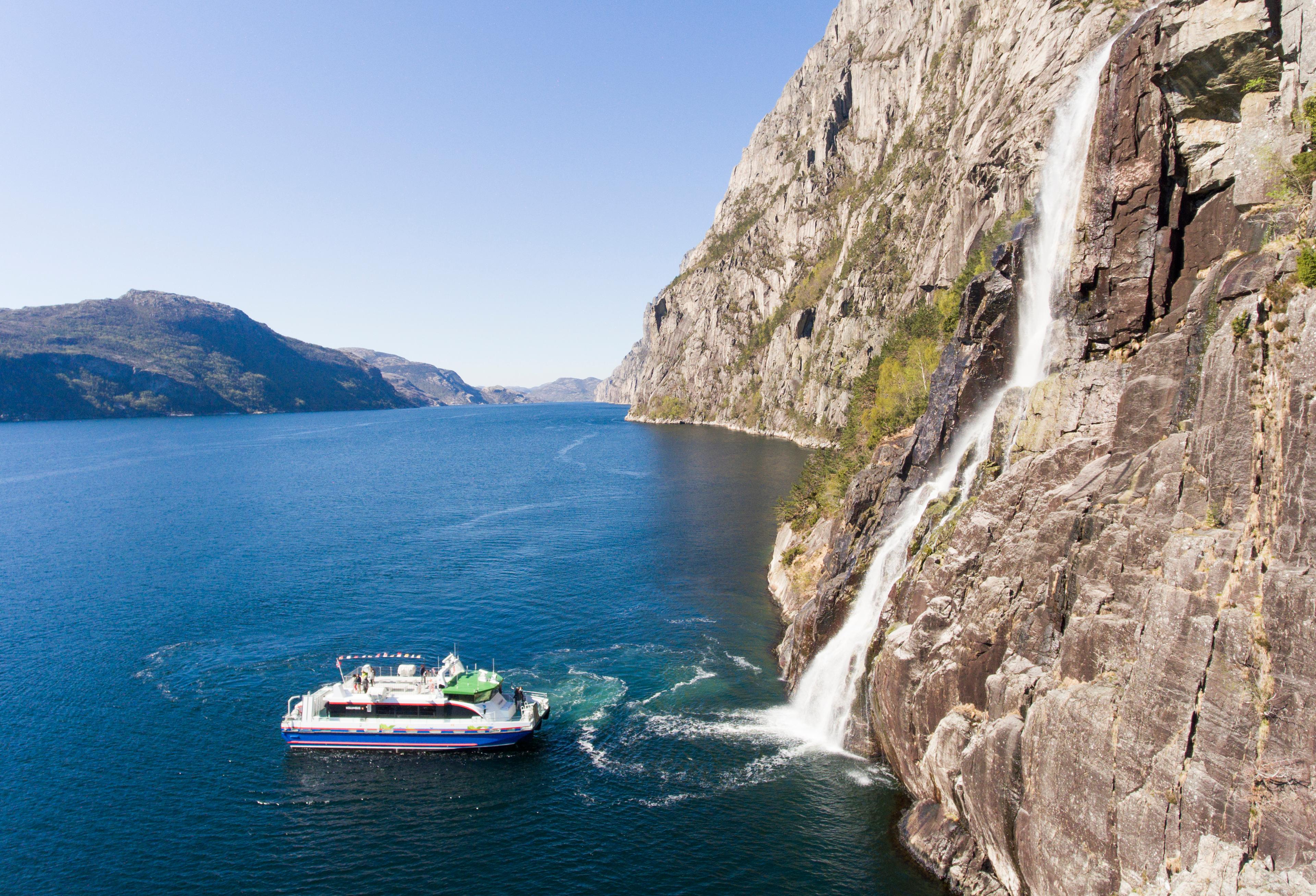 En båt på Lysefjorden som er på vei mot Hengjanefossen for å fylle drikkevann i en bøtte.