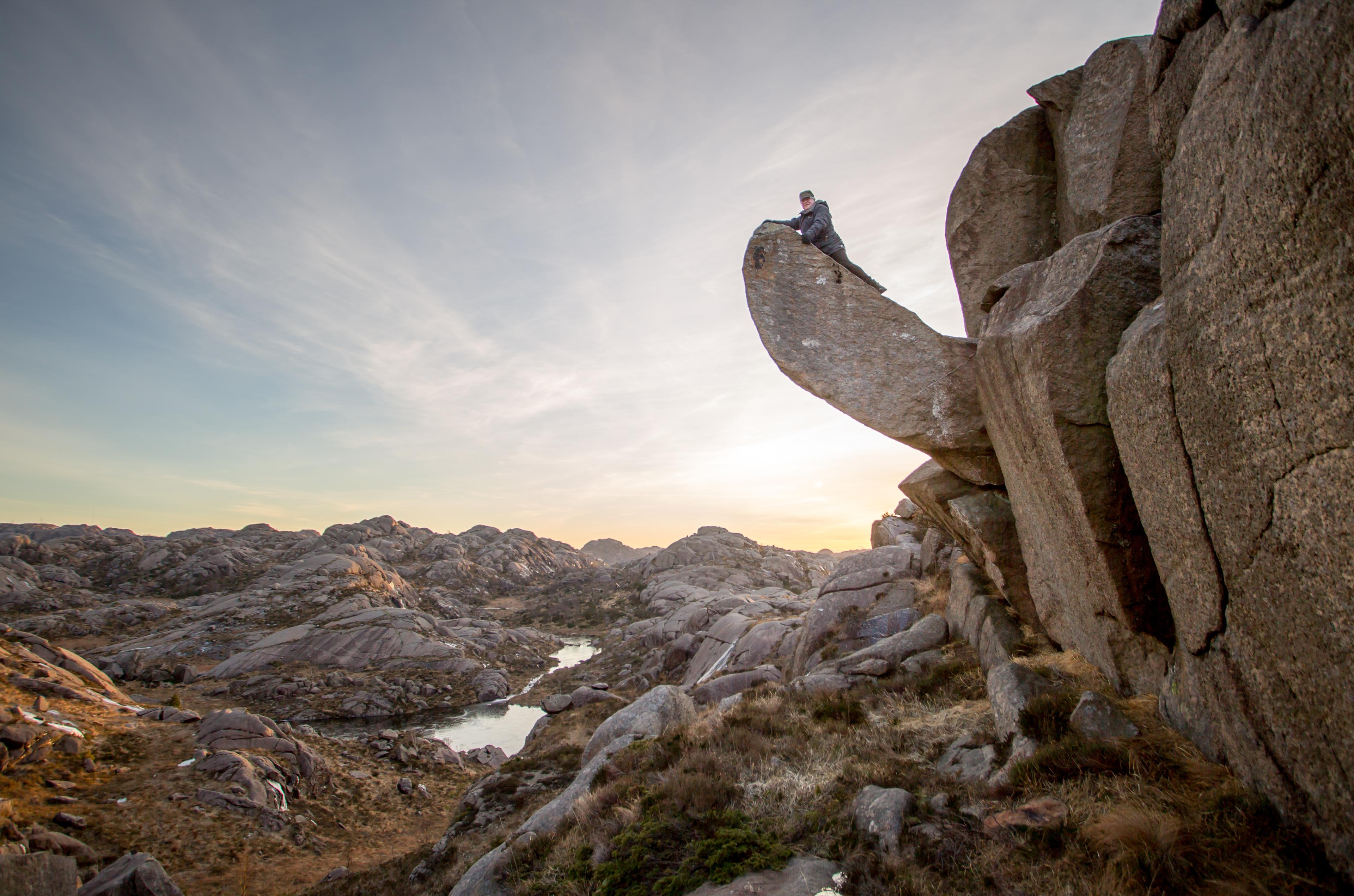 stone formation in nature called Trollpikken with person on top