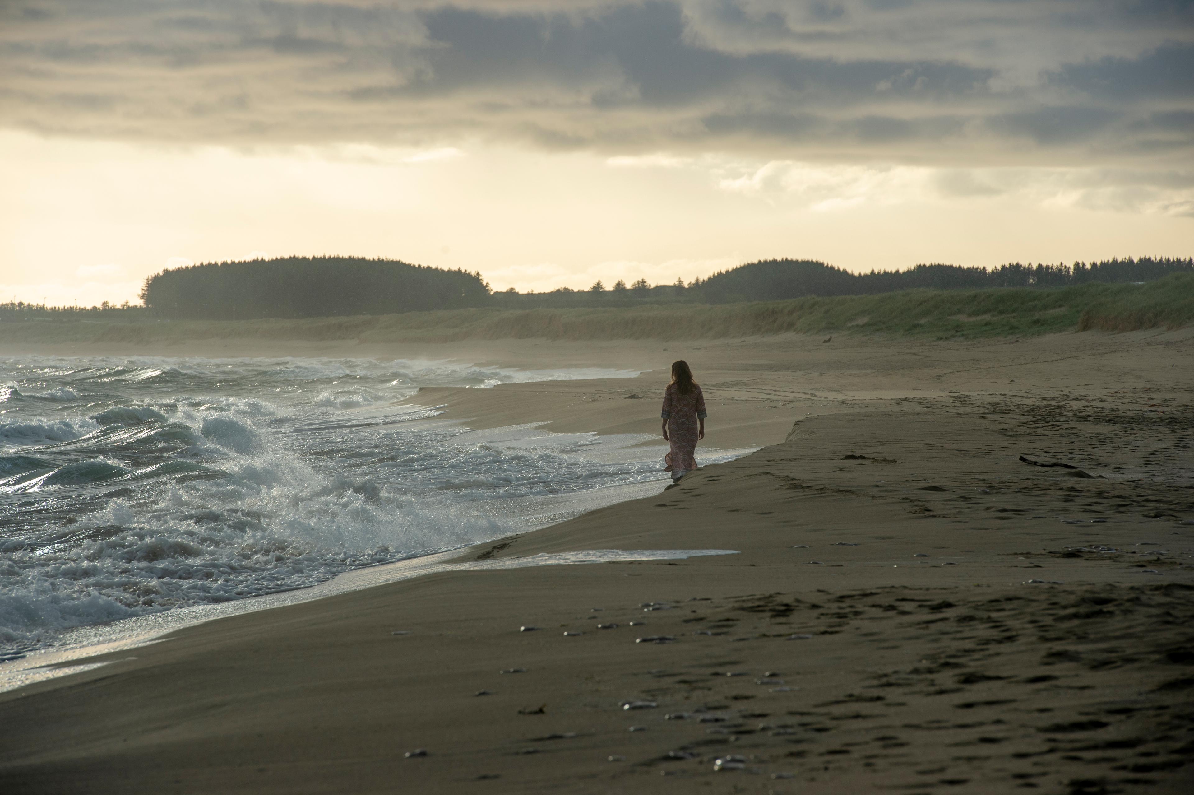 Lady walking on beach at brusand